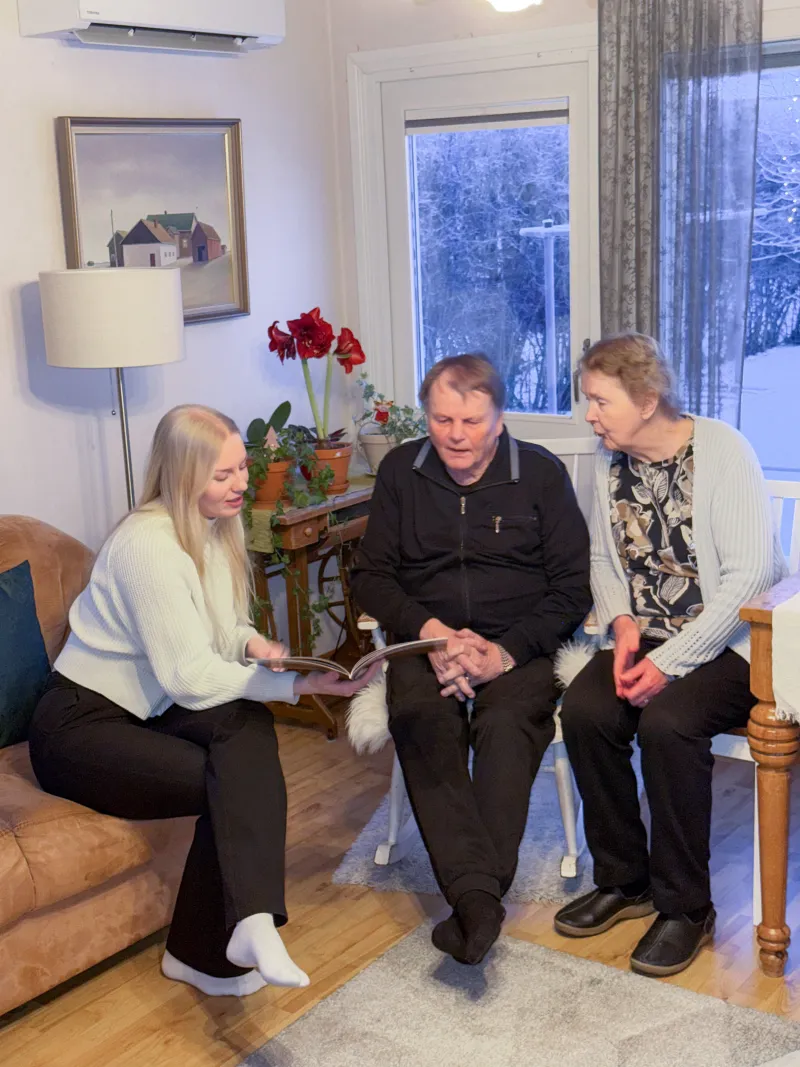 Helpen avustaja katsoo yhdessä ikäihmisten kanssa valokuvia