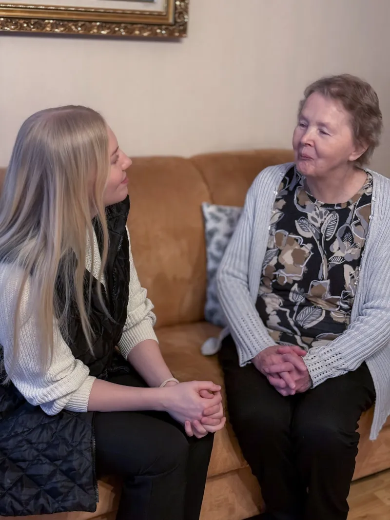 Helpen avustaja keskustelee ikäihmisen kanssa